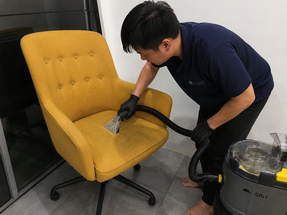 Oassist technician cleaning an armchair