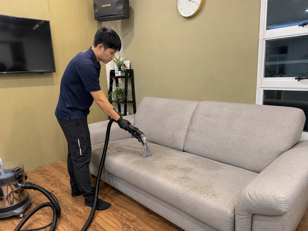 Oassist technician deep cleaning a sofa