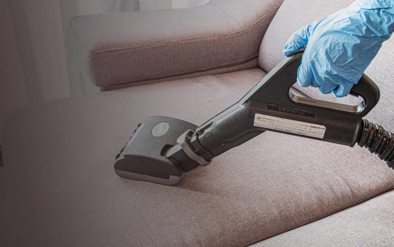Oassist crew deep-cleaning a fabric sofa with a professional steam extractor
